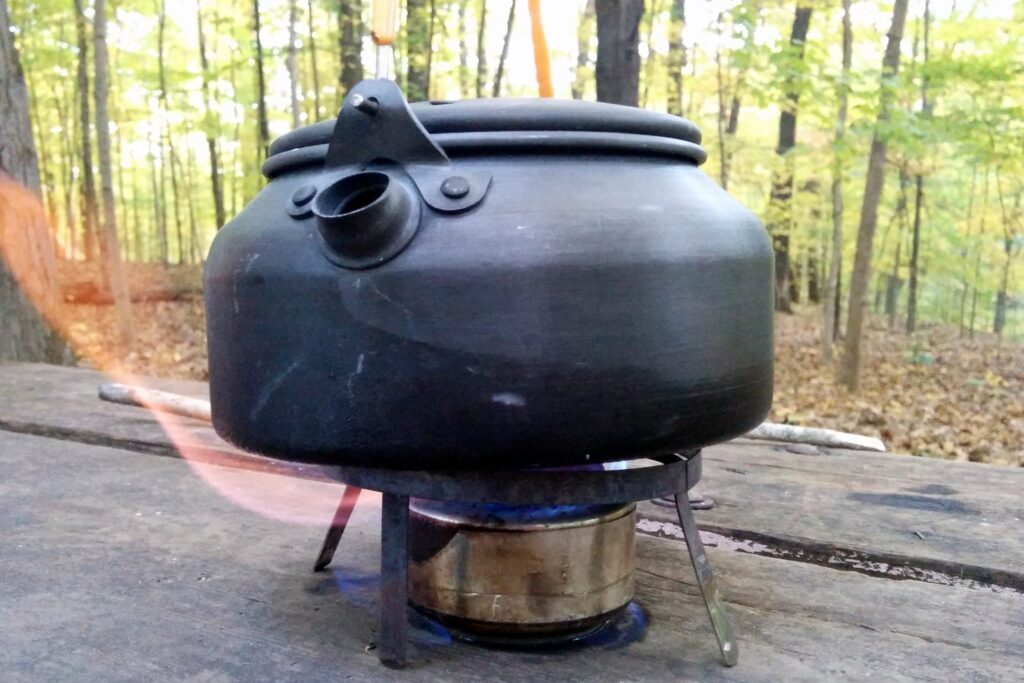 Hornillo a alcohol calentando agua en caldera de camping